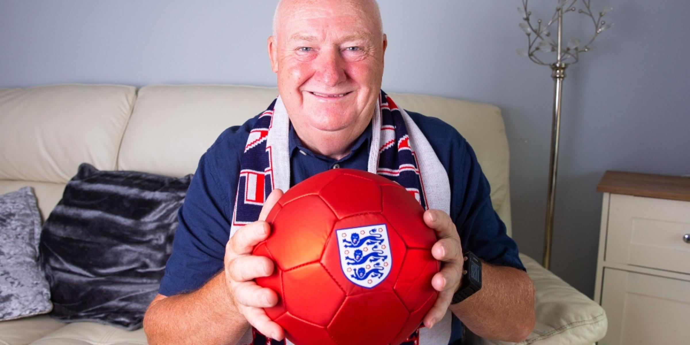 Tommy smiling, holding a red football