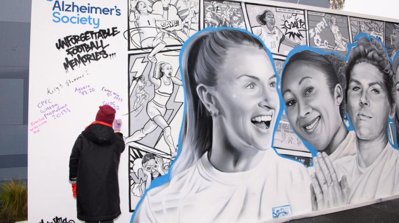 Picture of Leah Williamson, Lauren James and Millie Bright on a Alzheimer's Society mural
