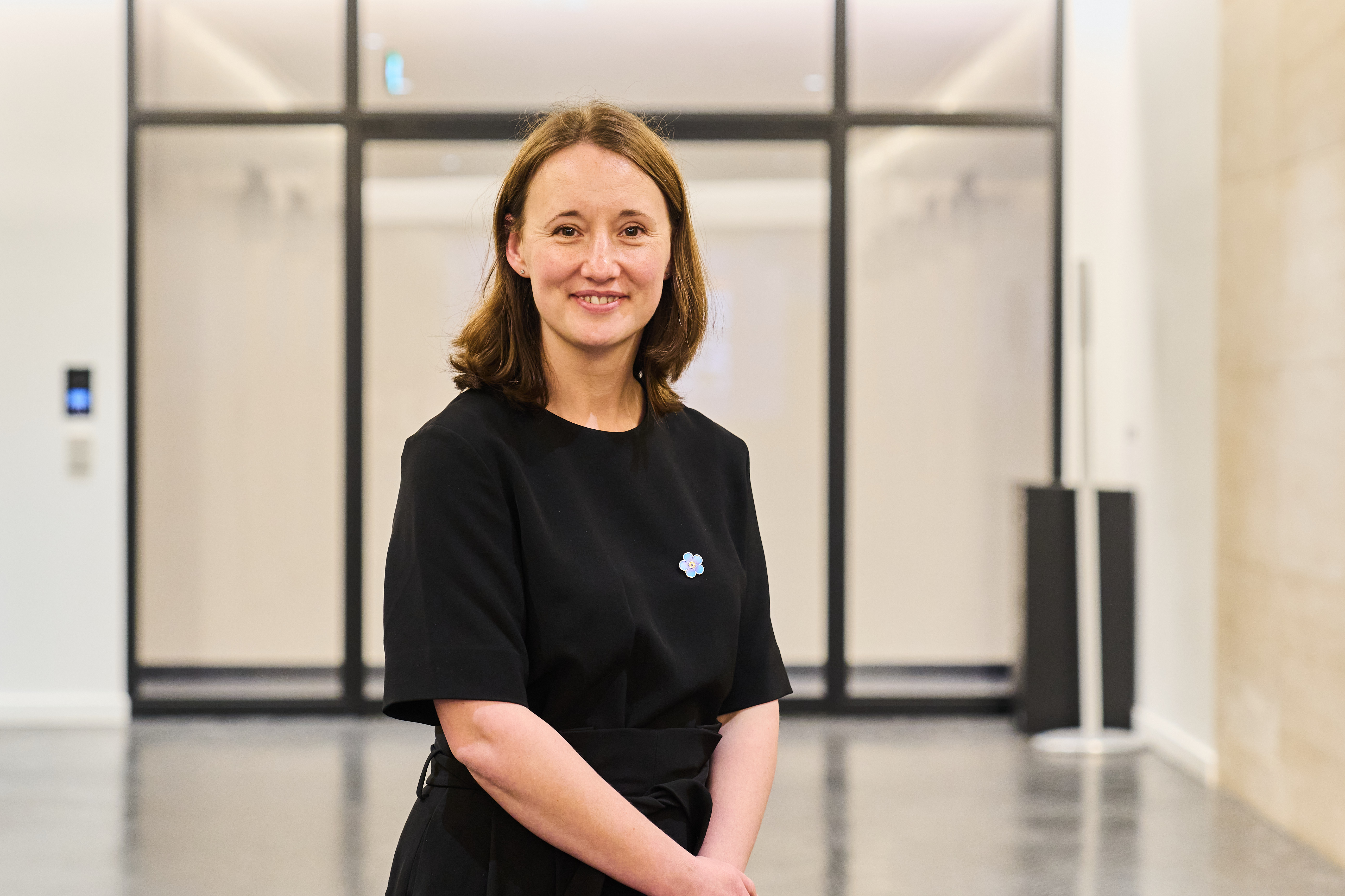 Photo of Alzheimer's Society Head of Policy Jennifer Keen. Jen is smiling and wearing a black dress with an Alzheimer's Society Forget Me Not flower pin badge