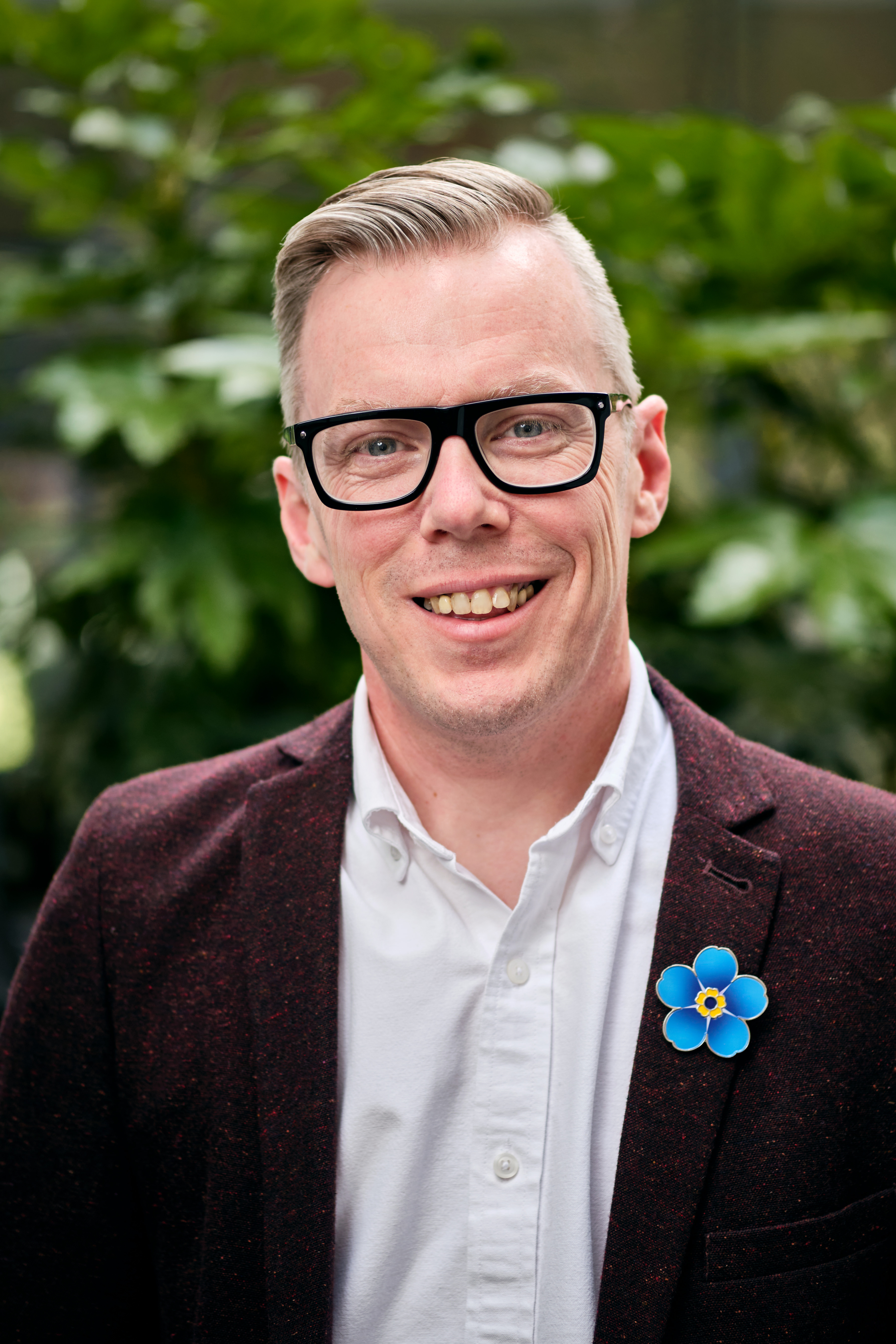 Photo of Alzheimer's Society Associate Director of Commercial and Partnerships. Paul is smiling and wearing an Alzheimer's Society Forget Me Not flower pin badge