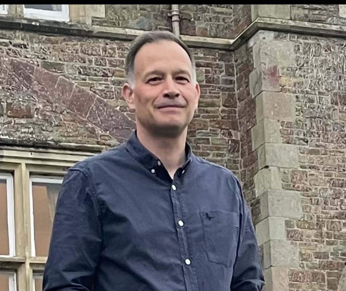 Photo of Alzheimer's Society Head of Local System Influencing Tim Baverstock. Tim is smiling and wearing a dark blue shirt