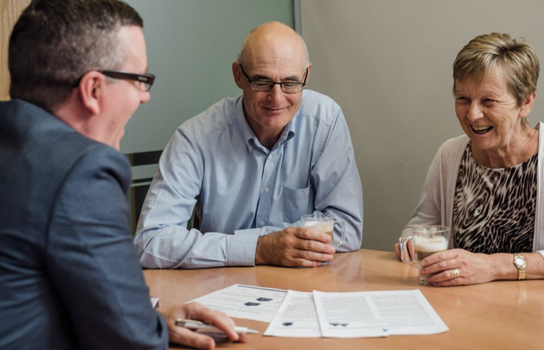 An older couple look through documents in a solicitors office.