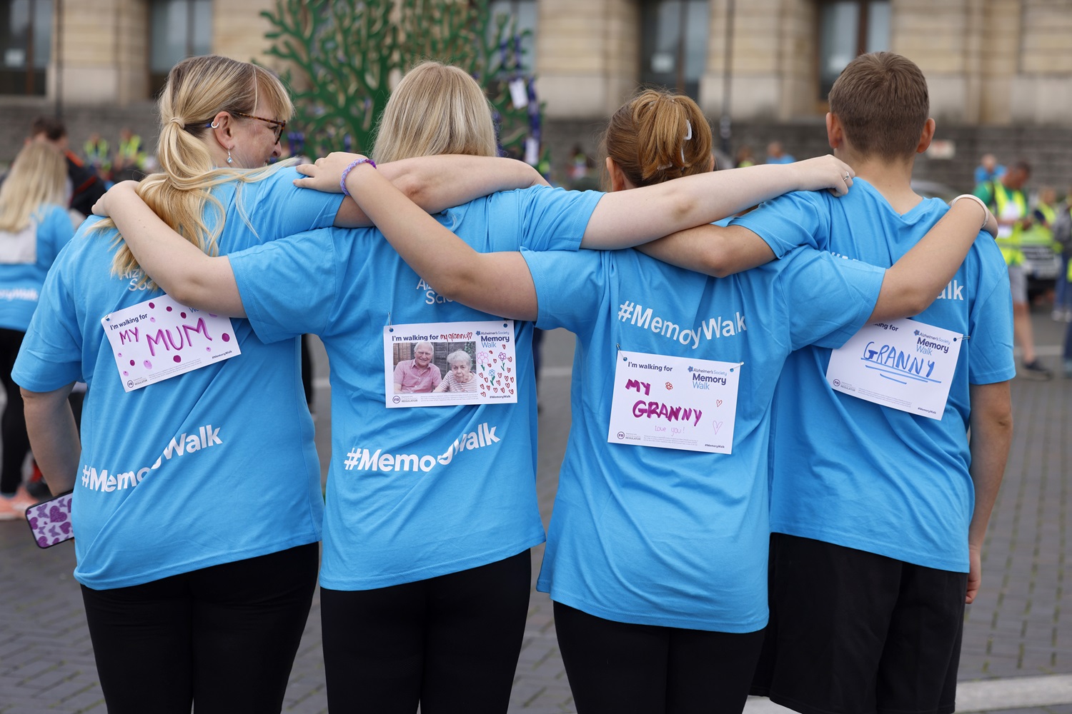 The backs of four Memory Walkers showing who they are walking for