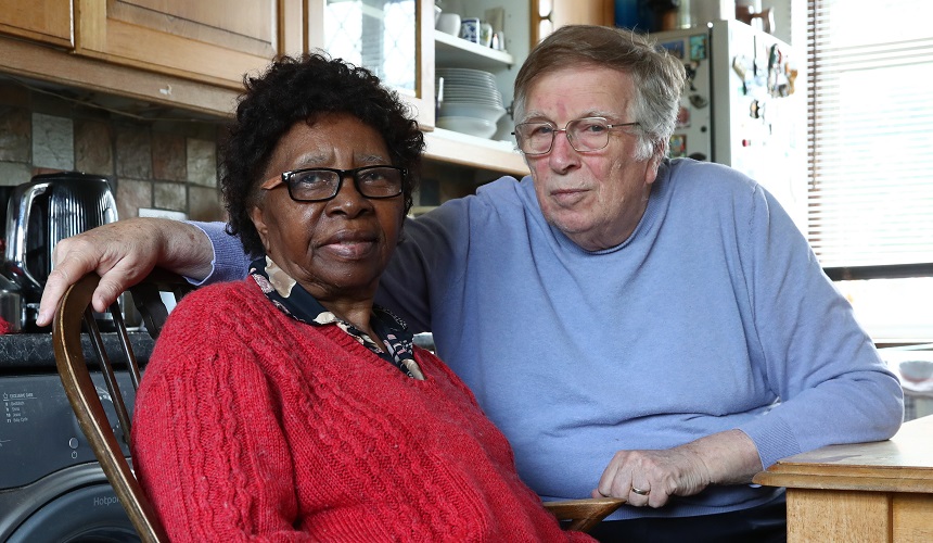 A man and woman sitting in their kitchen