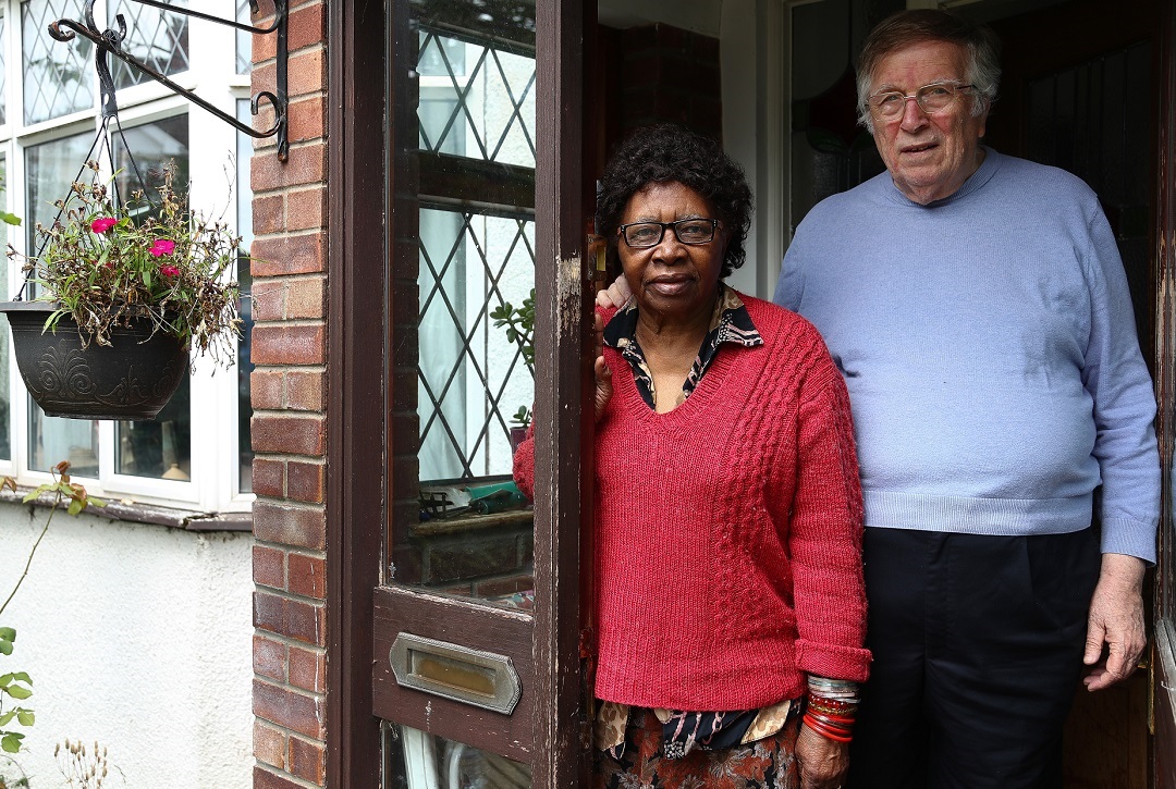 A couple standing outside their home