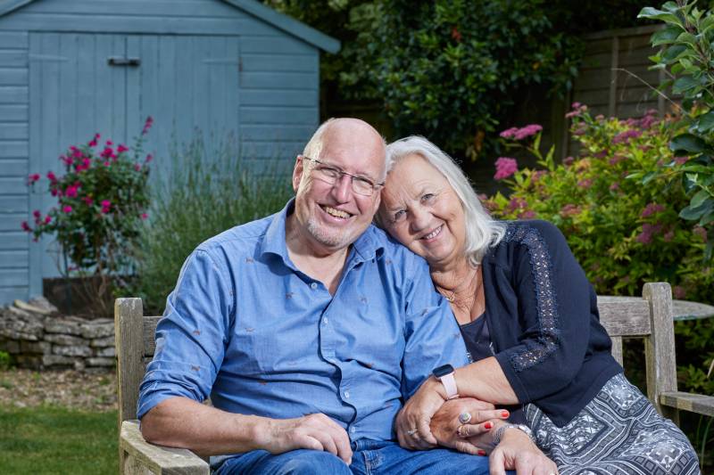 Two people are smiling and looking directly at the camera