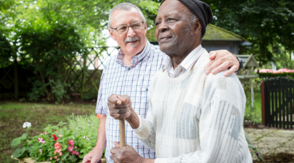 A man with dementia and his carer in a garden