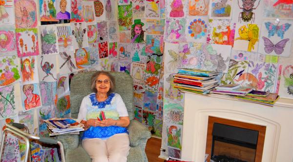 Woman sitting with her colouring artwork