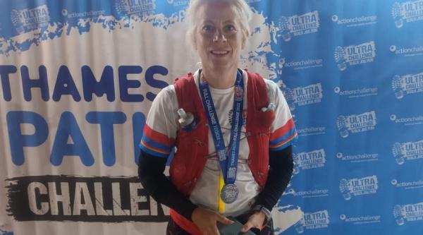 Judith wearing a medal for the Thames Path Challenge 100K