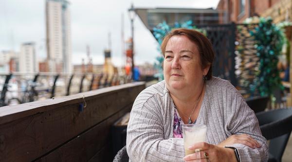 Dawn Davies sat outside drinking a coffee and looking into the distance