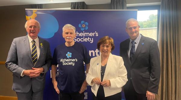 Jim Shannon MP, Alzheimer's Society Camapigner Jim, Diane Dodds MLA, National Influencing Officer Martin Reilly stood in front of Alzheimer's Society branding.