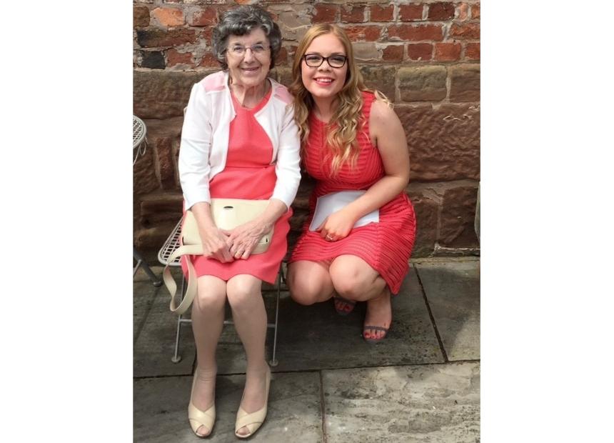 Evie and her nan, Barbara, in matching pink dresses at a wedding