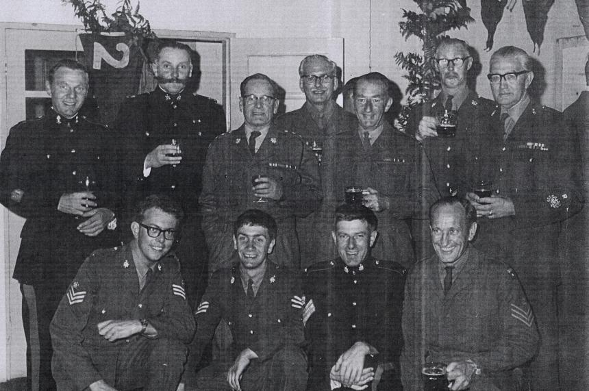 An old photograph of a troop of marines, where Ray sits in the middle