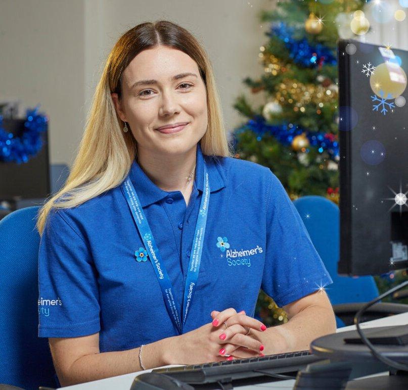 A dementia support worker sat in the office with a Christmas tree in the background