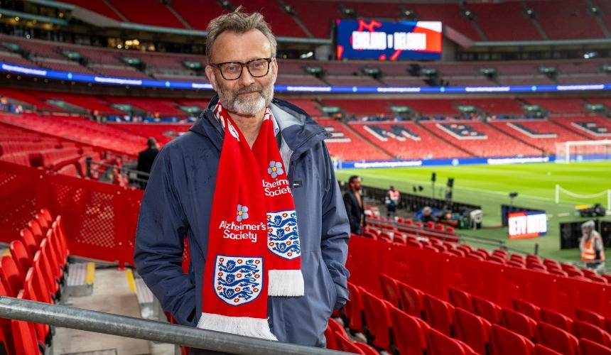 Hugh wearing an England scarf with the Alzheimer's Society logo on it