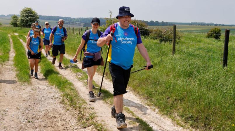 Group of people trekking through field 