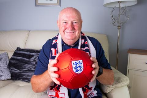 Tommy smiling, holding a red football