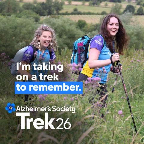 Two females trekking through a field with the text 'I'm taking on a trek to remember'