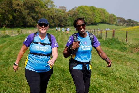 Two people trekking through a field