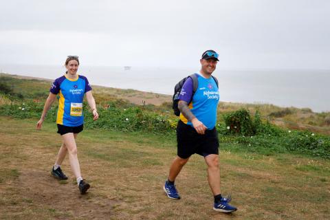 two trekkers walking along coastline