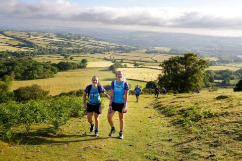 two pepple trekking through a field