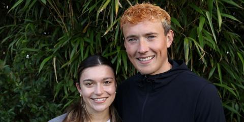 Agnes and Jordan stand together outside in front of trees