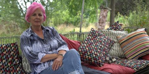 Mary sits on a sofa outside